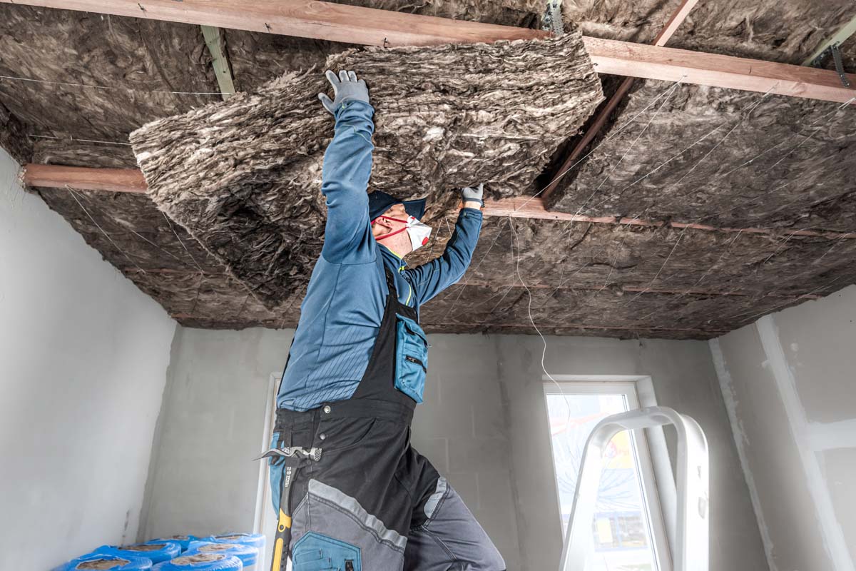 Ceiling insulation. The Worker putting a thermal insulation from glass wool.